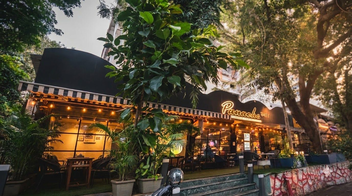 Panache café frontage in the evening with the illuminated Panache sign and striped awnings