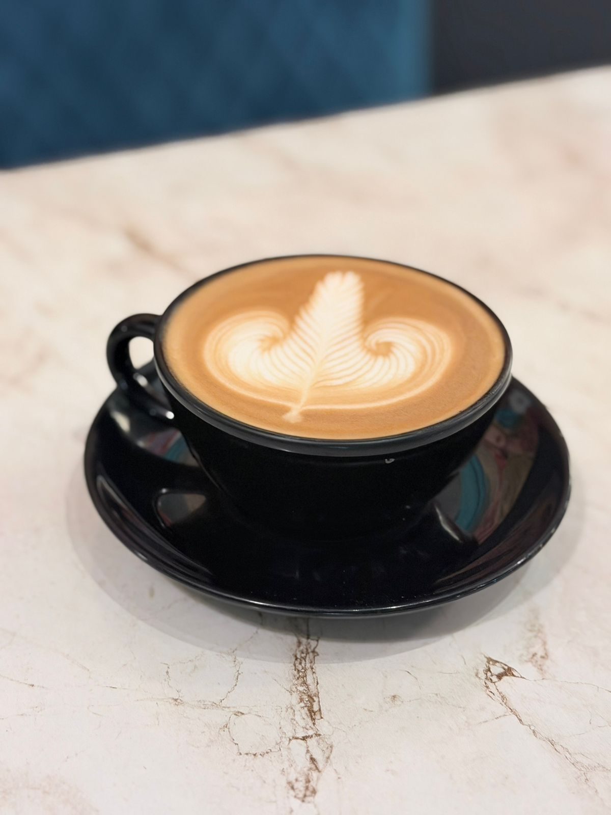 Overhead view of a latte and the wood-beamed ceiling at Panache